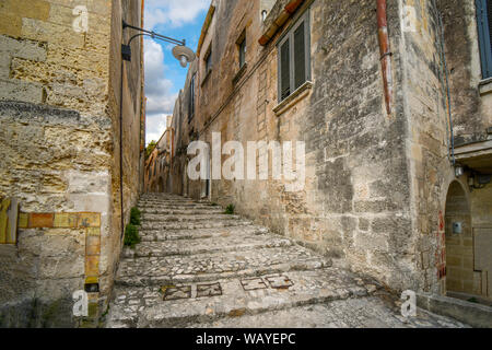 Eine breite Steintreppe führt hinauf zwischen Gebäude aus Stein in der antiken Stadt Matera, Italien, ein UNESCO-Weltkulturerbe in der Region Basilicata. Stockfoto