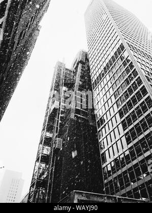 Graustufen vertikale Low-Angle-Aufnahme von Hochhäusern während Schnee Stockfoto