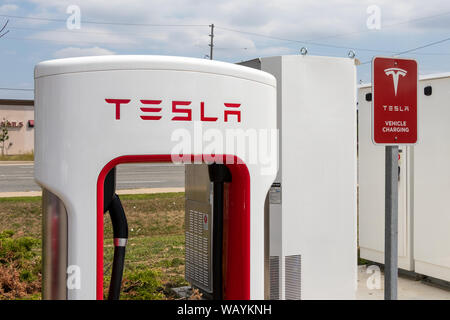 Tesla Kompressor und Tesla Fahrzeug Aufladen mit Power Technologie im Hintergrund. Stockfoto