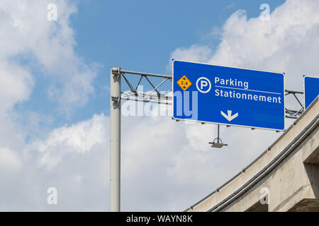 Parken Schild über der Straße am Flughafen in Englisch und Französisch. Stockfoto