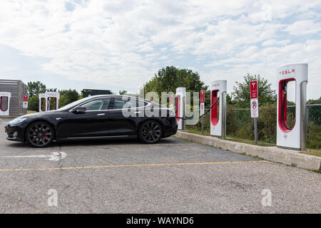 Schwarz Tesla Model S geparkt und der Ladevorgang bei Tesla Kompressor entfernt. Stockfoto