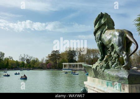 MADRID, Spanien - 23 April, 2018: Eine der Skulpturen von ein Löwe aus dem Denkmal des Königs Alfonso XII mit Blick auf den grossen Teich im Retiro Park, Madr Stockfoto