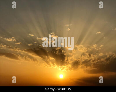 Sonnenuntergang mit Wolken und Sonnenstrahlen Stockfoto