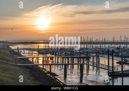 Ruhige Wellen am Strand und farbenfrohe Sonnenliegen am Langeoog Beach mit Einem wunderschönen blauen Himmel in Deutschland während des Sommers Stockfoto