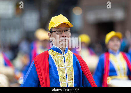 Holland, Michigan, USA - 11. Mai 2019: Tulip Time Parade, Chinesen, die traditionelle Kleidung, Spielen der Trommel während der Parade Stockfoto