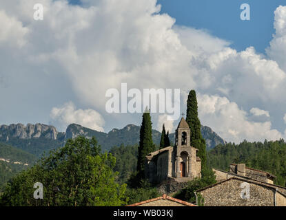 Die Kirche von St-Benoit-en-Diois mit Bergen und Gewitterwolken in der Drome Region in Frankreich Stockfoto