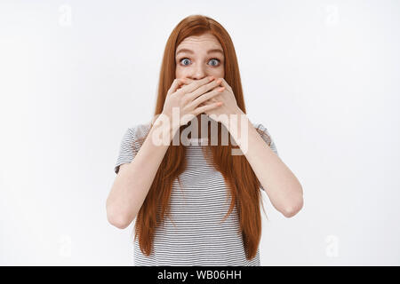 Schockiert junge rothaarige Mädchen unglaubliche Gerücht erfahren Sie amüsiert Augen weiteten sich überrascht die Augenbrauen heben Mund sprachlos keuchend stehen unter Staunen Stockfoto