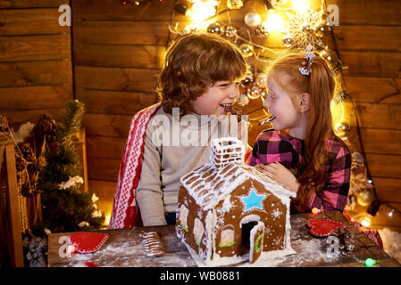 Glückliche Kinder mit Weihnachten Lebkuchen in einer eingerichteten Zimmer in den Urlaub. Stockfoto