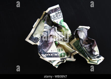 Hundert US-Dollar auf schwarzem Papier Hintergrund zerknittert, close-up der schlechten Geld. Der Zusammenbruch des Dollar. Abwertung. Fallende Währung. Stockfoto