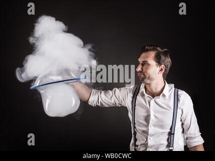 Künstler halten große Seifenblase mit dem Rauch in seine Hände. Bubble show studio Konzept. Stockfoto