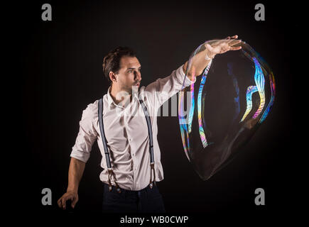 Künstler halten große Seifenblase in seinen Händen. Bubble show studio Konzept. Stockfoto