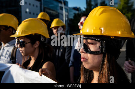 Berlin, Deutschland. 23 Aug, 2019. Demonstranten stand auf eine Mahnwache mit gelben Helm, Schutzbrille und symbolisch fallenden rechten Auge vor der chinesischen Botschaft und fordern Freiheit für Hongkong. In der ehemaligen britischen Kronkolonie Hong Kong es massive Proteste gegen die Regierung seit mehr als zwei Monaten. Die Demonstrationen wurden durch eine Gesetzesvorlage der Regierung mutmaßlichen Straftätern nach China um die Auslieferung von ausgelöst. Credit: Paul Zinken/dpa/Alamy leben Nachrichten Stockfoto