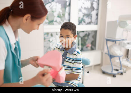 Kind Zahnarzt zeigt Zähne Modell süße dunkelhäutige Junge Stockfoto