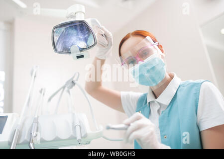 Weiblichen Zahnarzt tragen Schutzbrille Prüfung Patienten Stockfoto