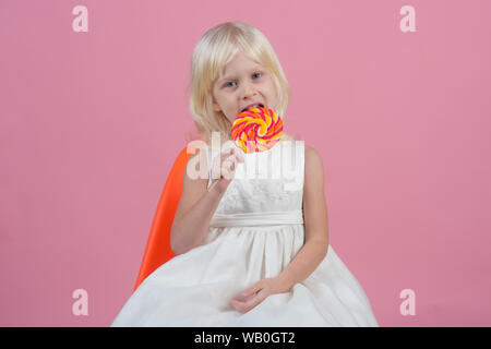 Ein riesiger whirly Pop kann sehr lange dauern. Glückliche Kindheit essen. Kleines Mädchen halten Lollipop auf Stick. Kleines Kind mit süßen Lutscher. Happy candy Stockfoto