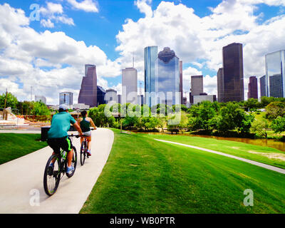 Reiten Fahrräder auf befestigte Weg in Houston Park (Blick auf den Fluss und die Skyline der Innenstadt von Houston) - Houston, Texas, USA Stockfoto
