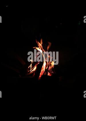 Vertikale Aufnahme eines Lagerfeuers oder Lagerfeuers im Dunkeln Bereich für Hintergrund oder Hintergrundbild Stockfoto