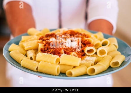 Glückliche Frau zeigt ihre Nudeln kochte sie 5 Minuten vor - Erwachsener oder Senior zu Hause Kochen in der Küche Essen mit Fleisch - Vorbereitung Küchenchef italienische Küche mit Stockfoto