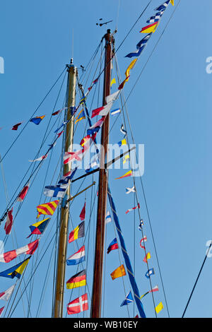 Verschiedenen internationalen Nautischen Flaggen auf dem Mast eines Segelboot Mast sind im Wind flattern Stockfoto