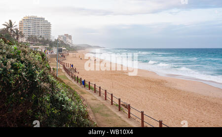 DURBAN, Südafrika - 13. AUGUST 2019: Menschen zu Fuß auf den Strand und die Promenade am Strand in Umhlanga Rocks in der Nähe von Durban KwaZulu-Natal Südafrika Stockfoto