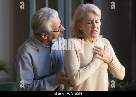 Besorgt, älteren Mann helfen Frau berühren Brust, Herzinfarkt Stockfoto