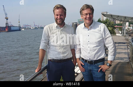 23. August 2019, Hamburg: Der Fraktionsvorsitzende von Bündnis 90/Die Grünen, Anjes Tjarks (l) und der Fraktionsvorsitzende der SPD in der Hamburger Bürgerschaft, Dirk Kienscherf, stehen an den Landungsbrücken. Sozialdemokraten und Grüne in Hamburg und Rotterdam wollen die Zusammenarbeit zwischen den beiden Hafenstädte bei der Verringerung der Luftverschmutzung durch Seeschiffe abgegeben zu fördern. Foto: Martin Fischer/dpa Stockfoto