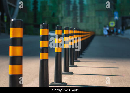 Eine Reihe von gelben Barrieren auf der Straße, die Trennung der Verkehrswege und die Fußgängerzone Stockfoto