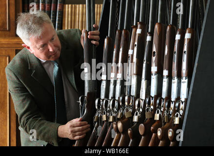 Versteigerer Gavin Gardiner Blick eine Auswahl an modernen und klassischen Jagdwaffen auf der Anzeige vor der Gavin Gardiner Ltd jährliche Auktion der Moderne und klassische Sportwaffen in Gleneagles Hotel. Stockfoto