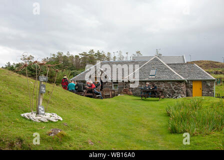 Die Menschen sitzen außerhalb des Tee Shop Port Mor Insel von Muck die kleinen Inseln Schottland Kunden traditionellen, aus Stein gebauten schottische Insel cottag Stockfoto