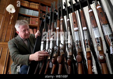 Versteigerer Gavin Gardiner Blick eine Auswahl an modernen und klassischen Jagdwaffen auf der Anzeige vor der Gavin Gardiner Ltd jährliche Auktion der Moderne und klassische Sportwaffen in Gleneagles Hotel. Stockfoto