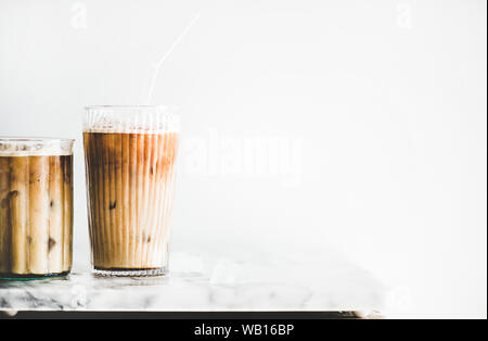 Iced Latte Kaffee in Gläser mit Strohhalmen auf Tisch, Nahaufnahme Stockfoto