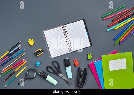 Flach Foto von Arbeitsbereich Schreibtisch mit Schule Zubehör oder Bürobedarf auf grauem Hintergrund. Stockfoto