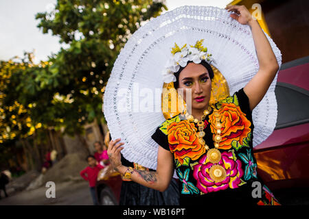 Eine Mexikanische "Muxe" (in der Regel, ein homosexueller Mann, der weiblichen Kleidung) stellt eine Kopfbedeckung während des Festivals in Juchitán de Zaragoza, Mexiko. Stockfoto