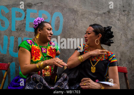 Mexikanische "muxes" (typischerweise, homosexuelle Männer tragen weibliche Kleidung) aufgeregt sprechen während des Festivals in Juchitán de Zaragoza, Mexiko. Stockfoto