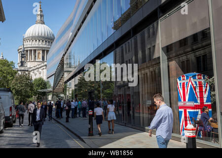 Mit der Kuppel der St. Paul's Cathedral am Ende der Mittagspause, die in der City arbeiten, vorbei an den Union Jack - Themen Telefon Kiosk in Starkoch Gordon Ramsay's Restaurant Bread Street Küche auf (der ehemaligen römischen Durchgangsstraße) Watling Street, in der City von London, das Finanzviertel der Hauptstadt (aka der Square Mile), am 22. August 2019, in London, England. Stockfoto