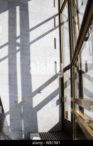 Schatten in einem hellen Interieur mit Wänden aus Marmor auf einem hellen, sonnigen Tag. Hintergrund und Trendanalyse schattenlinien von Tür und Fenster Stockfoto