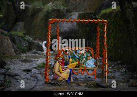 Kathmandu, Nepal. 23 Aug, 2019. Ein Anhänger sitzt vor dem götzen von Lord Krishna und Radha während Krishnas Janmashtami, die jährliche Hindu Festival feiert den Geburtstag von Lord Krishna in Kathmandu, Nepal am Freitag, den 23. August 2019. Credit: Skanda Gautam/ZUMA Draht/Alamy leben Nachrichten Stockfoto