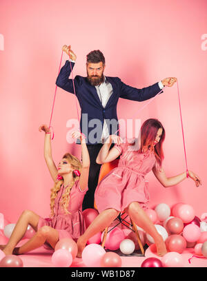 Kreative Idee. Liebe Dreieck. Feiertage und Puppen. Dominanz und Abhängigkeit. Vintage Mode Frauen Puppe und Mensch. retro Mädchen und Master im Party ball Stockfoto