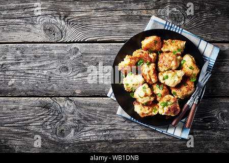 Marokkanische Tempura - Stil gebratenen Blumenkohlröschen auf einer schwarzen Platte auf einem alten Holztisch serviert, Ansicht von oben, Nahaufnahme, flatlay, leeren Raum Stockfoto