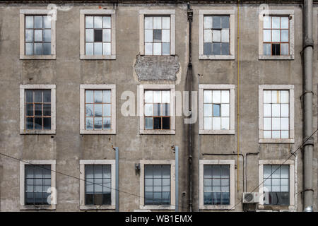 Nahaufnahme Landschaft detail Architektur Blick auf 3 Reihen von Fensterrahmen und Scheiben in verschlissenen Zustand in Beton wand Fassade der industriellen Gebäude in L Stockfoto