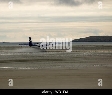 Barra Airport, Äußere Hebriden, Schottland. Der loganair Twin Otter Flugzeuge landen und am Flughafen. Stockfoto