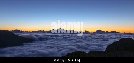 Die Gipfel der Dolomiten im Morgengrauen. Sonneneinstrahlung bei Sonnenaufgang. Wolkenflut über Tälern. Trentino. Italienische Alpen. Europa. Stockfoto