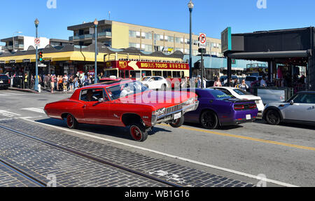 SAN FRANCISCO, CA/USA - 30. APRIL 2017: Mexikanische Amerikaner fahren einen roten Chevrolet Impala lowrider in den Straßen von San Francisco. Stockfoto