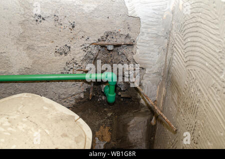 Neue Kunststoff Wasserleitungen in Abgekratzt Badezimmer Wand während der Renovierungsarbeiten installiert Stockfoto