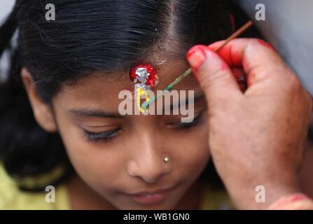 Kathmandu, Nepal. 23 Aug, 2019. Ein Mädchen erhält Tika als Segen von einem Priester während Krishna Janmasthami Festival in Krishna Mandir Tempel in Kathmandu, Nepal, 23.08.2019. Krishna Janmasthami Festival wird jährlich feierten den Geburtstag des hinduistischen Gottes Krishna zu markieren. Credit: Sunil Sharma/Xinhua Stockfoto