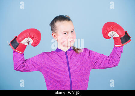 Weibliche Boxer. Sport Erziehung. Boxing strenge Disziplin. Mädchen niedliche Boxer auf blauem Hintergrund. Große Macht bedeutet große Verantwortung. Im Gegensatz zu den Stereotypen. Boxer Kind in Boxhandschuhen. Stockfoto