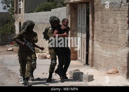 Nablus, Palästina. 23 Aug, 2019. Israelische Soldaten verhaften einen palästinensischen Demonstrant bei Auseinandersetzungen, nach einem Protest gegen den Ausbau jüdischer Siedlungen in Kufr Qadoom Dorf in der Nähe der Stadt Nablus im Westjordanland, 23.08.2019. Quelle: Xinhua/Alamy leben Nachrichten Stockfoto