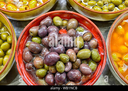 Marinierte Oliven mit Kräutern auf dem Markt. Stockfoto