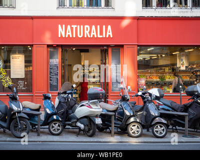 PARIS, FRANKREICH - 03. AUGUST 2018: Motorroller vor dem Naturalia Health Food Shop in der Rue Beaubourg geparkt Stockfoto