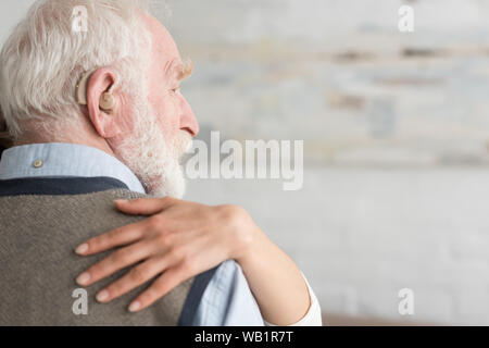 7/8-Ansicht von Frau Hand auf grauhaariger Mann Stockfoto